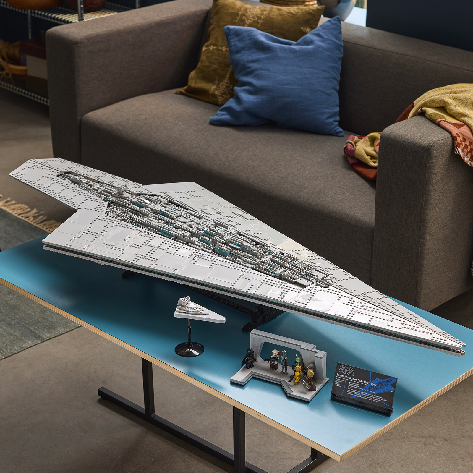 LEGO Star Wars 75457 Executor Super Star Destroyer exposé sur une table bleue premium dans un salon, avec son mini Star Destroyer, ses figurines et sa plaque collector.